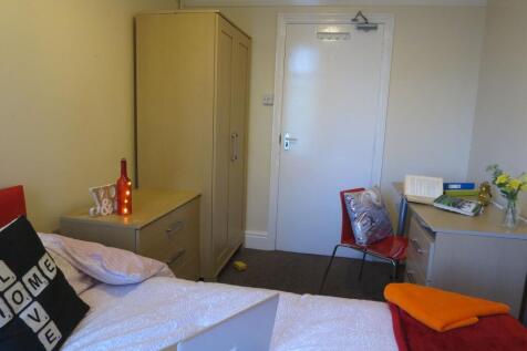Bright, neatly furnished single bedroom with a ...