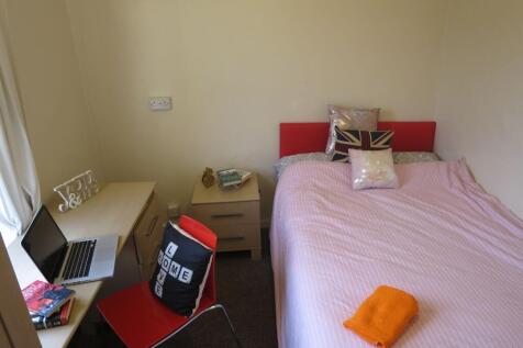 Cozy single bedroom with a neatly made bed, che...