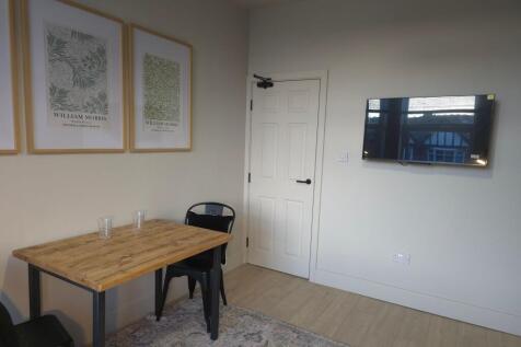 Bright, neatly furnished communal lounge with a...