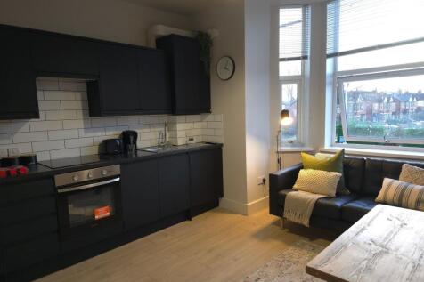 Modern open-plan kitchen with matte dark cabine...
