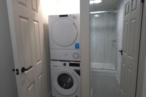 Modern en-suite style bathroom with a tiled wal...