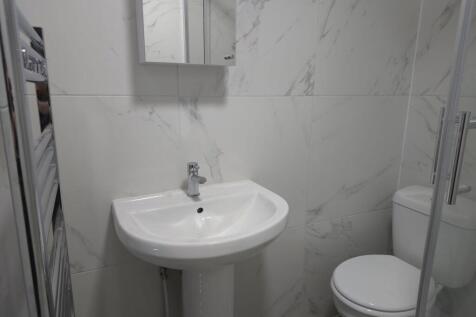 Modern compact bathroom with a pedestal sink, m...