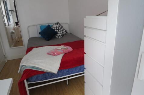 Bright, simply furnished single bedroom with a ...