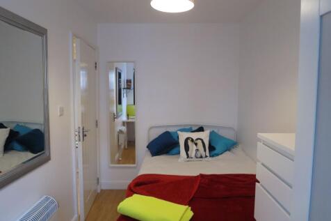 Bright, neatly presented bedroom featuring a co...