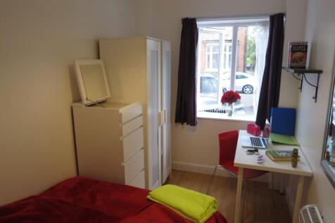 Bright, neatly furnished single bedroom with a ...