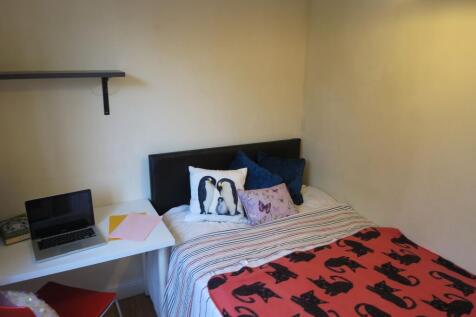 Cozy single bedroom with a comfortable bed, pat...