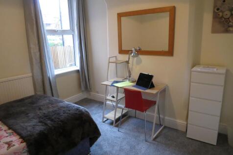 Bright, neatly presented bedroom with a study a...