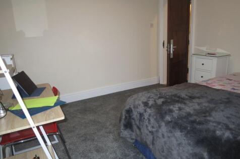 Well-kept bedroom with cosy bedding, a desk wor...