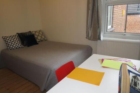 Bright, simply styled bedroom with a neatly mad...