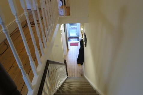 Bright, well-maintained hallway and staircase w...