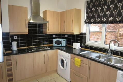 Contemporary fitted kitchen with light wood cab...