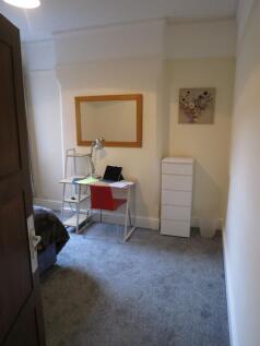 Neat furnished bedroom with a desk, study lamp ...