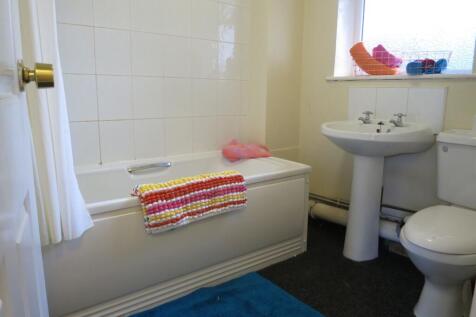 Clean, functional bathroom with a white bath an...