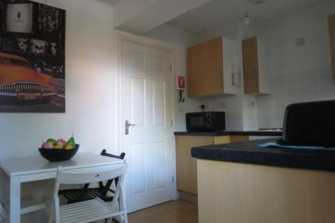 Bright compact kitchen with light wood cabinets...