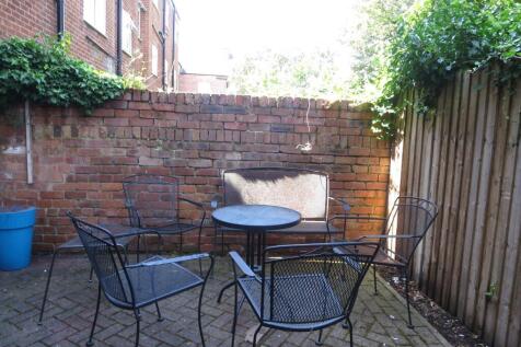 Sunny private paved courtyard with metal outdoo...