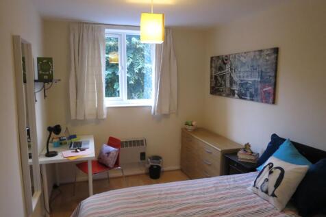 Bright, neatly furnished bedroom with a comfort...