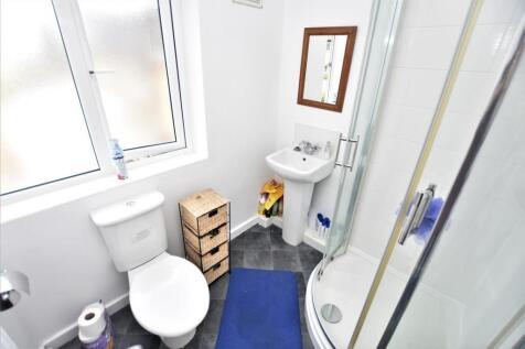 Bright, modern bathroom with a corner shower en...