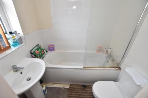 Compact bathroom with a bathtub and shower scre...