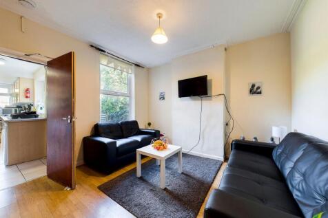 Bright furnished living room with two black lea...