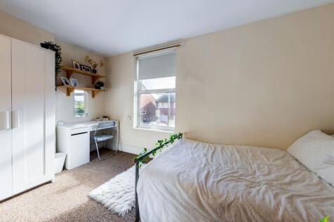 Bright, neatly styled double bedroom with a com...