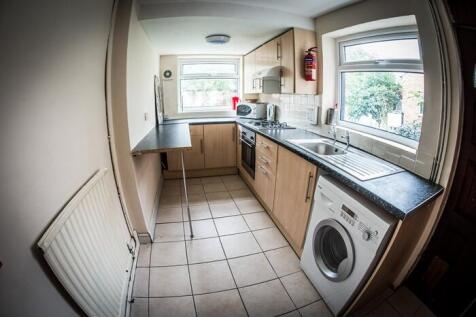 Bright galley kitchen with light wood cabinetry...