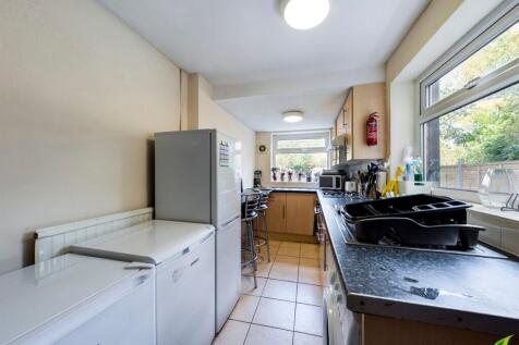 Bright galley kitchen with large window overloo...