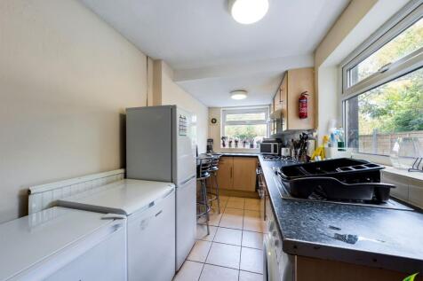 Bright galley kitchen with large windows overlo...