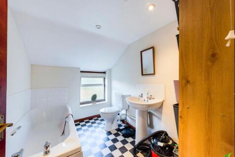 Bright bathroom with a checked tile floor, whit...