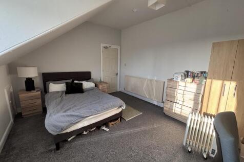 Spacious attic-style bedroom with a double bed,...