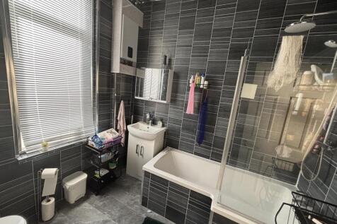 Modern bathroom with charcoal tiled walls, a ba...