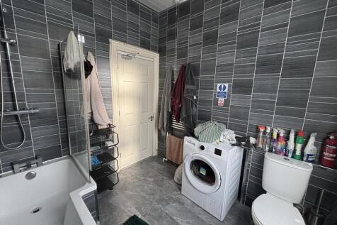 Modern tiled bathroom with a bathtub and wall-m...