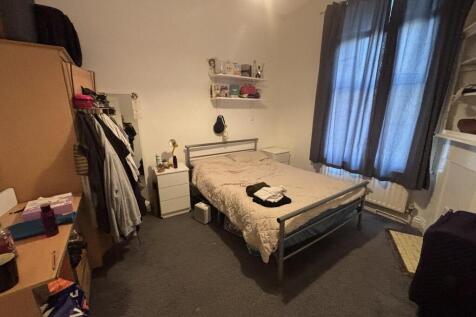 Bright, neatly kept double bedroom with a metal...