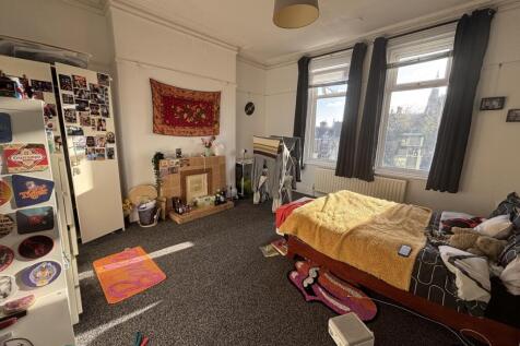 Bright, well-lit bedroom with large windows, ne...