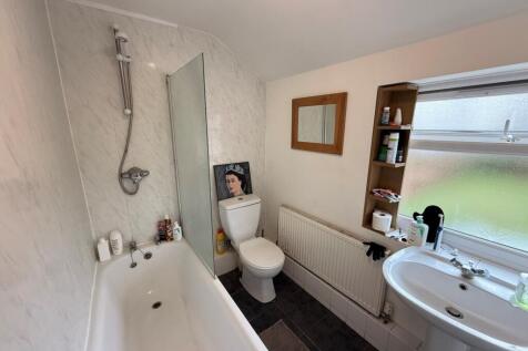Bright, well-maintained bathroom with a bath an...