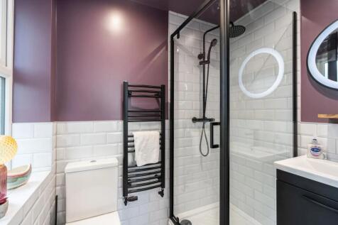 Modern bathroom featuring a sleek black shower ...
