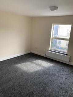 A spacious and tidy living room with a large wi...