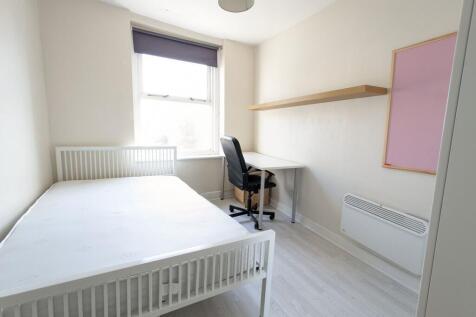 Bright, simply furnished bedroom with a white b...