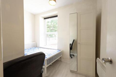 Bright, simply furnished bedroom with a large f...