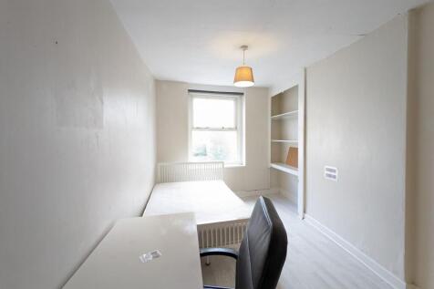 Bright, simply furnished bedroom with a single ...