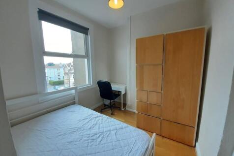 Bright double bedroom with a large window, simp...