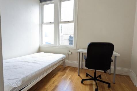 Bright, simply furnished single bedroom with a ...