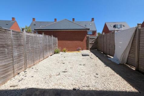 Sunny low-maintenance rear garden with pale gra...