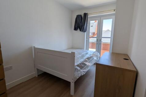 Bright, simply furnished bedroom with a white s...