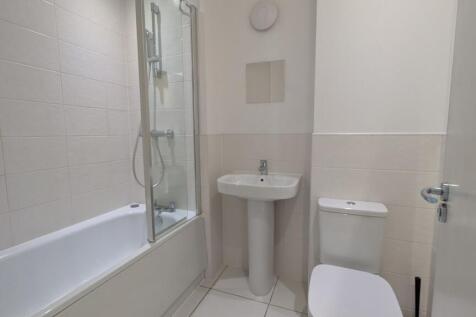 Bright, modern bathroom with a tiled shower-ove...