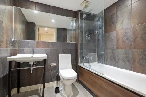 Modern tiled bathroom with a full bathtub and g...