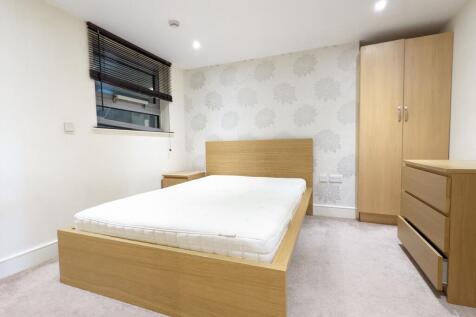 Bright, modern bedroom with a wooden bed frame,...