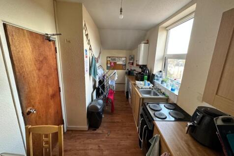 A well-lit kitchen with ample storage and works...