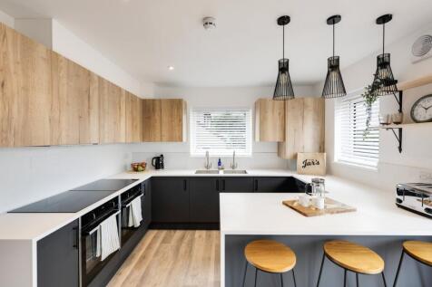 A modern and tidy kitchen with ample natural li...