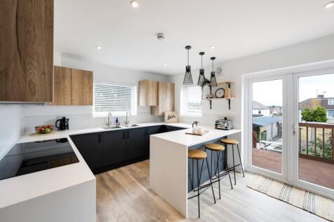 A bright and modern kitchen with stylish cabine...