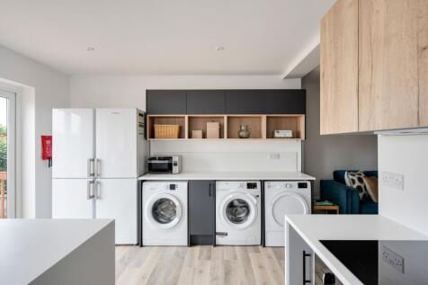 Bright, modern kitchen/laundry area with integr...